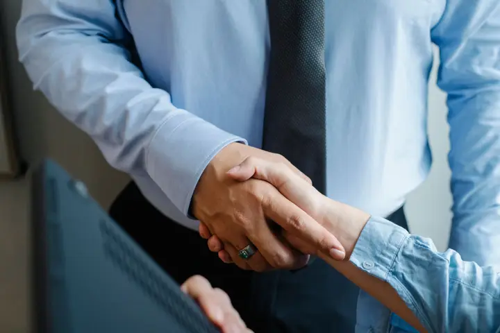 Two colleagues shaking hands in an office